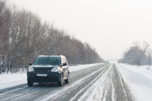 Black car on a winter road with winter tires